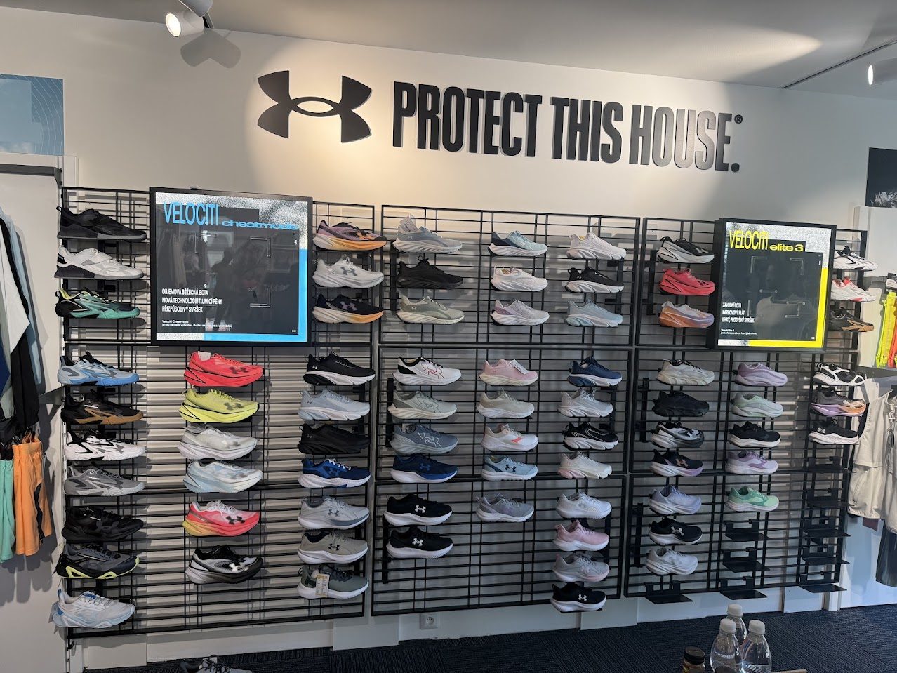 Stěna s vystavenou sportovní obuví Under Armour