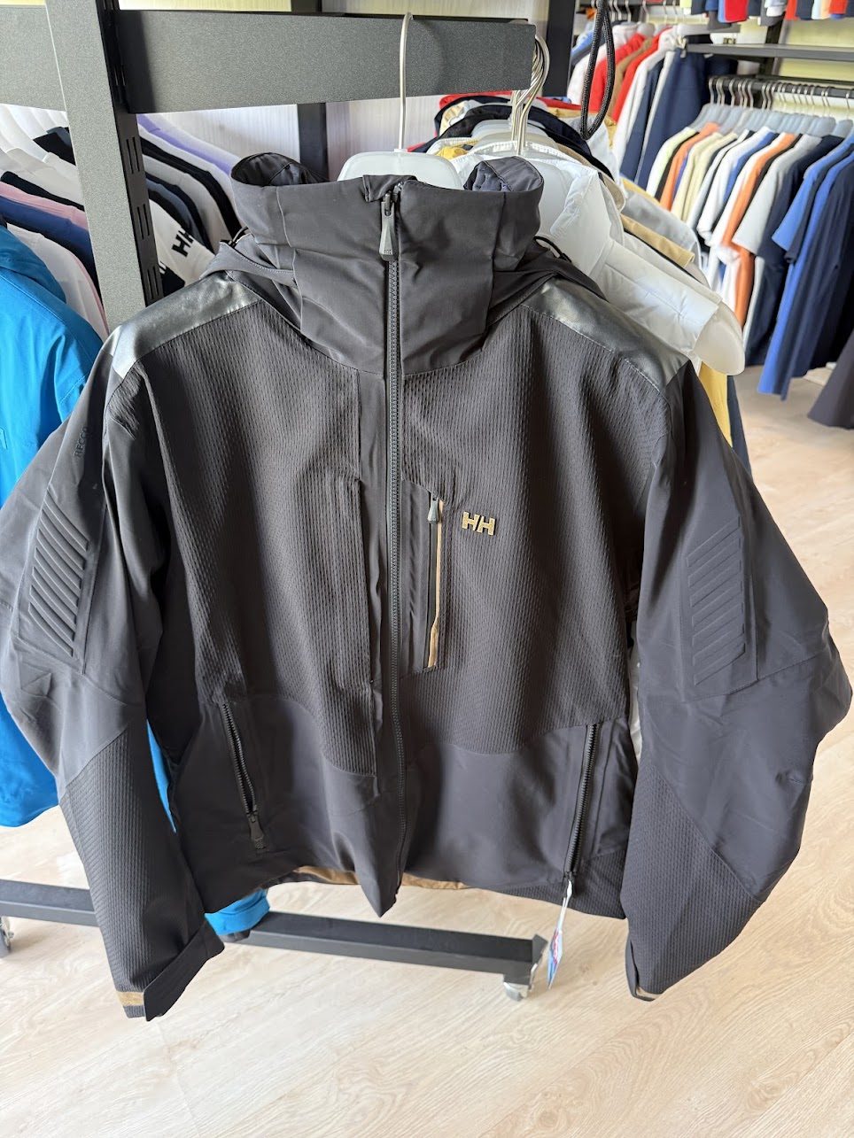 Tmavá technická bunda Helly Hansen na ramínku s kapucí a zipy