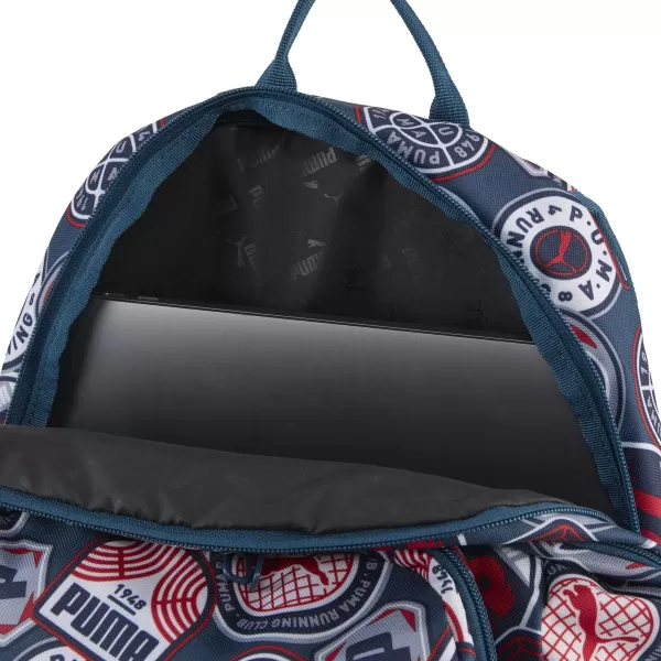  Batoh PUMA ACADEMY AOP BACKPACK 09115027 MIDNIGHT PETROL/FOR ALL TIME RED/RUNNING BADGES AOP 